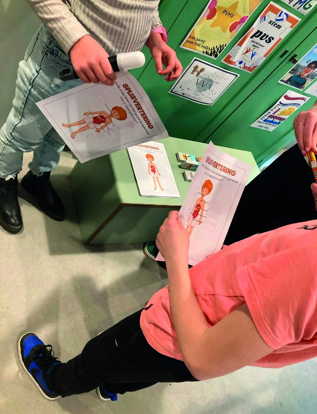 Kinderen werken met werkbladen over de spijsvertering